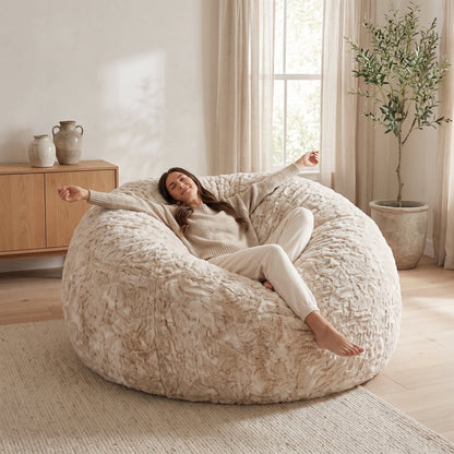 Pouf géant XXL beige dans un salon lumineux, femme allongée qui s'étire